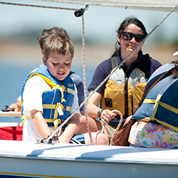 A mother with her kids on a sail boat